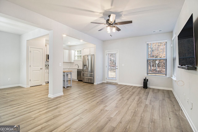 unfurnished living room with ceiling fan and light hardwood / wood-style flooring