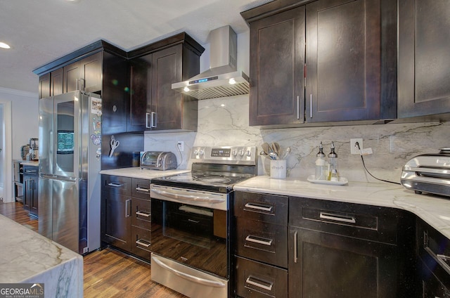 kitchen with stainless steel appliances, light stone countertops, dark hardwood / wood-style flooring, and wall chimney exhaust hood