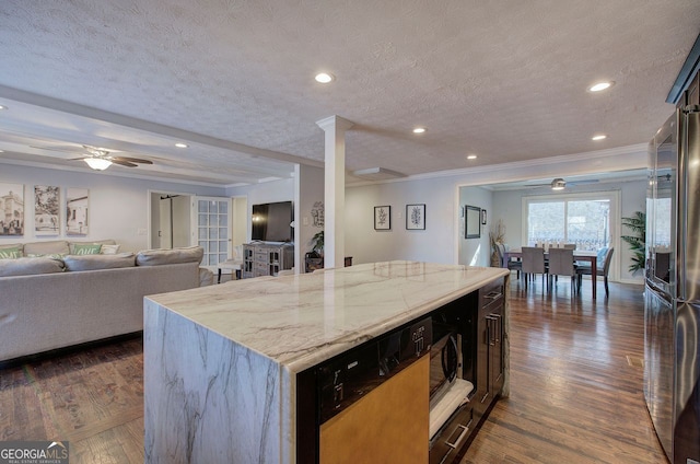 kitchen featuring a center island, light stone counters, a textured ceiling, dark hardwood / wood-style flooring, and high end refrigerator