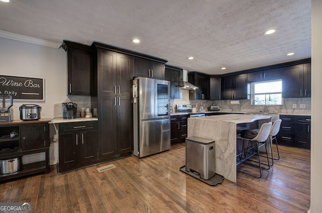 kitchen with stainless steel appliances, dark hardwood / wood-style flooring, a center island, and decorative backsplash