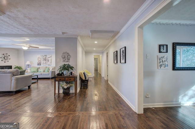 hall with ornamental molding, dark wood-type flooring, and a textured ceiling