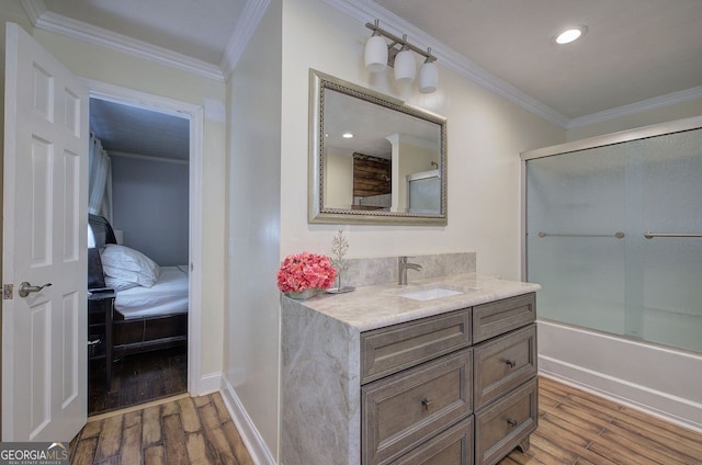 bathroom with hardwood / wood-style flooring, crown molding, vanity, and shower / bath combination with glass door