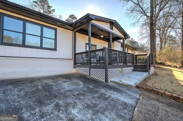 view of property exterior featuring ceiling fan, a deck, and a patio