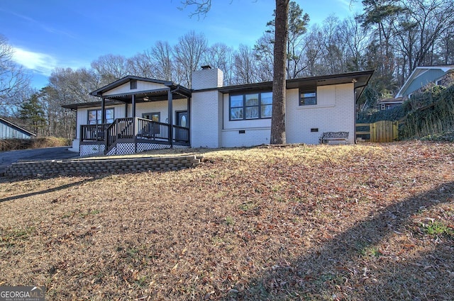 rear view of property featuring a wooden deck