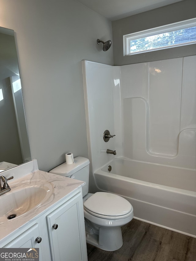 full bathroom featuring wood-type flooring, tub / shower combination, vanity, and toilet