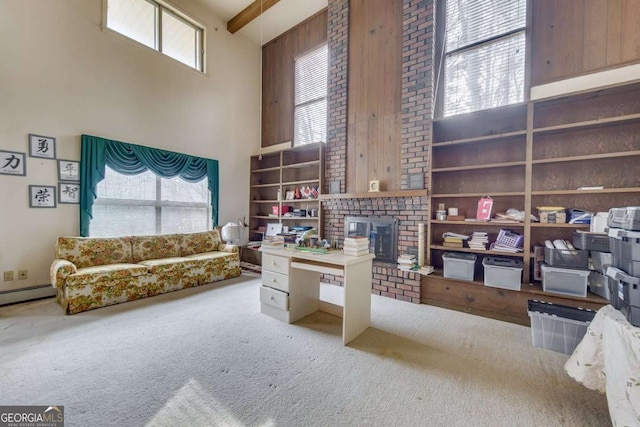 interior space featuring baseboard heating, a towering ceiling, carpet flooring, and beam ceiling