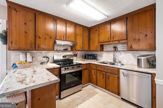 kitchen featuring tasteful backsplash, appliances with stainless steel finishes, kitchen peninsula, and sink