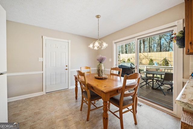 dining area featuring a chandelier and a textured ceiling