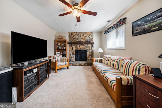 living room with ceiling fan, a fireplace, light colored carpet, and a textured ceiling