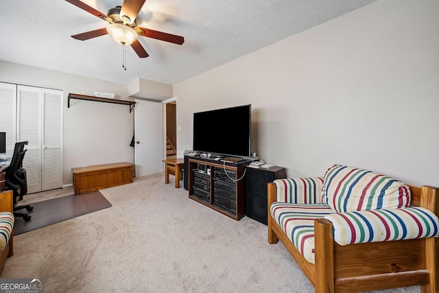 carpeted living room featuring a textured ceiling and ceiling fan