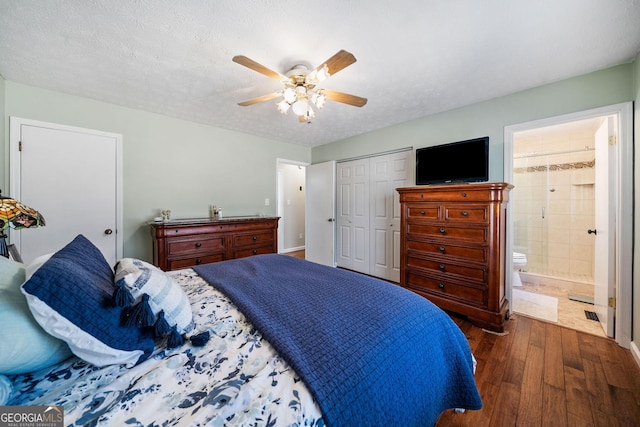 bedroom with connected bathroom, a textured ceiling, dark hardwood / wood-style floors, a closet, and ceiling fan