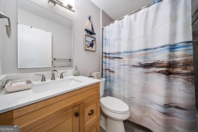 bathroom featuring vanity, toilet, and a textured ceiling