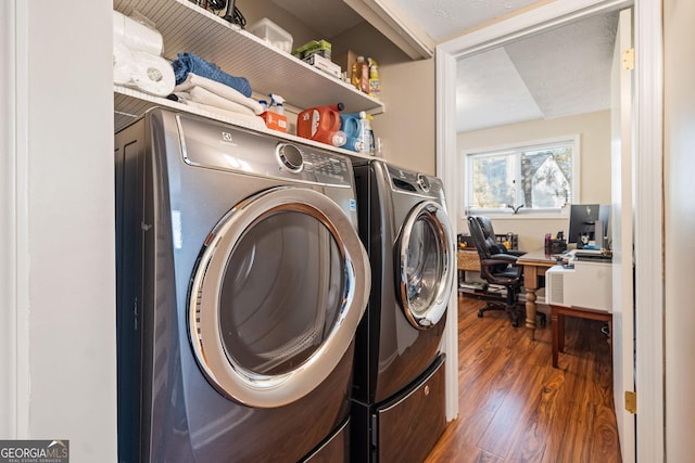 clothes washing area with washer and dryer and dark hardwood / wood-style flooring