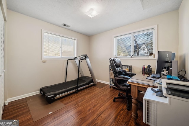 home office featuring dark hardwood / wood-style floors and a textured ceiling