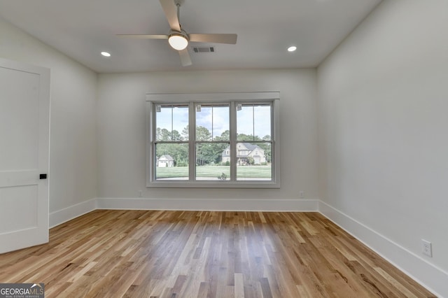 empty room with ceiling fan and light hardwood / wood-style floors