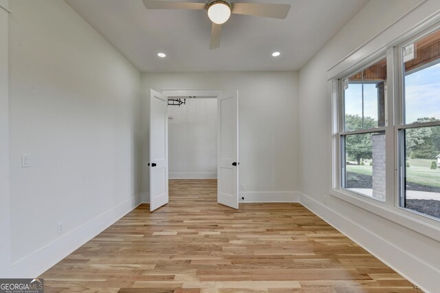 spare room with light hardwood / wood-style flooring and ceiling fan