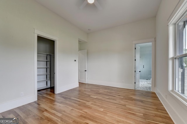 unfurnished bedroom with connected bathroom, light hardwood / wood-style floors, and ceiling fan