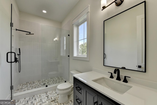 bathroom featuring vanity, toilet, and a shower with shower door