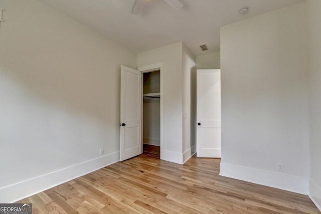 unfurnished bedroom featuring ceiling fan, light wood-type flooring, and a closet