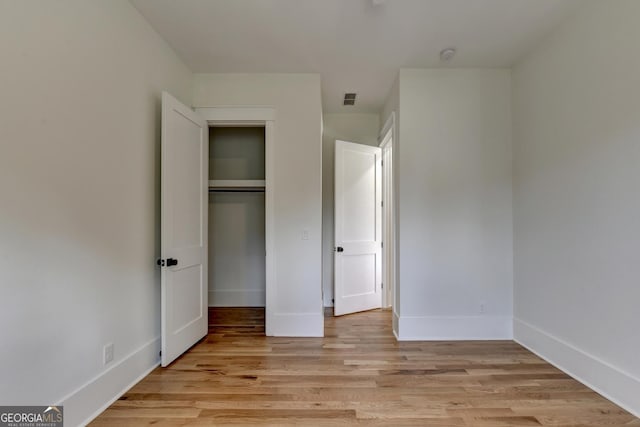 unfurnished bedroom with a closet and light hardwood / wood-style flooring