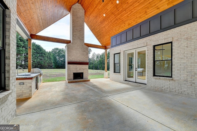 view of patio featuring french doors and an outdoor fireplace