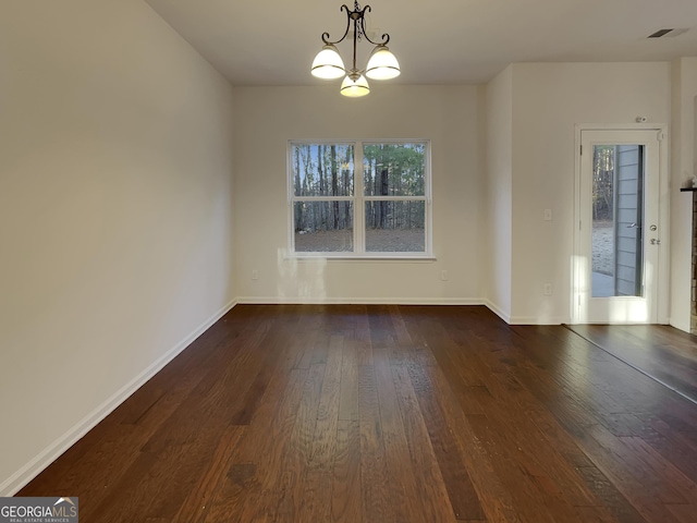 unfurnished dining area featuring dark wood-type flooring and a chandelier