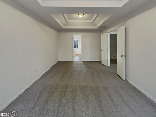 carpeted empty room featuring a tray ceiling