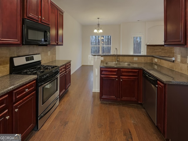 kitchen featuring pendant lighting, sink, stainless steel appliances, dark hardwood / wood-style flooring, and decorative backsplash