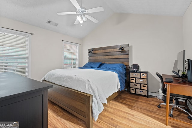 bedroom with ceiling fan, lofted ceiling, and light wood-type flooring