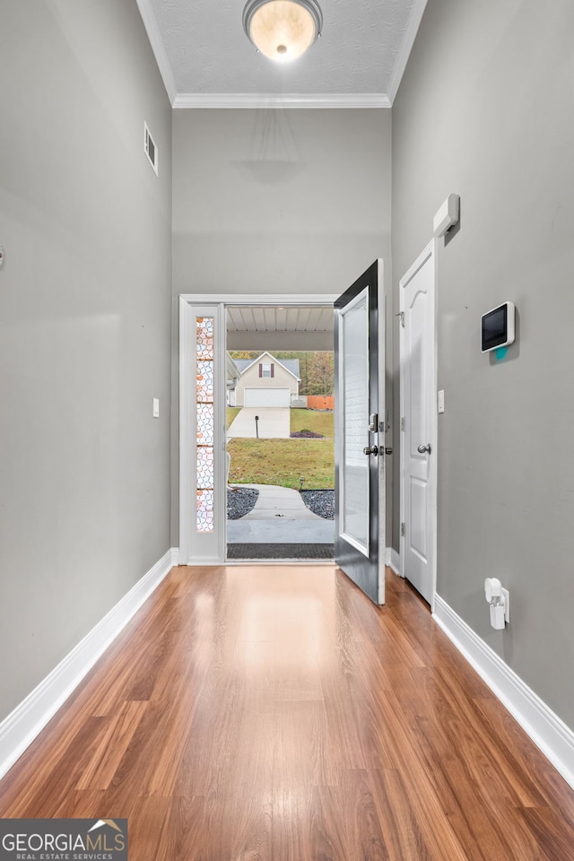 entrance foyer with hardwood / wood-style flooring and crown molding