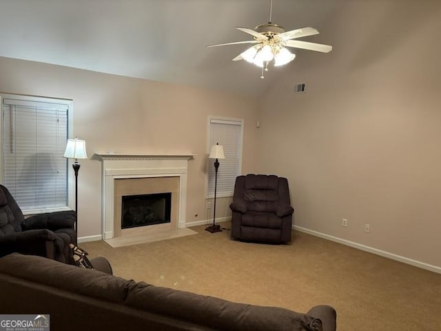 carpeted living room with ceiling fan and vaulted ceiling