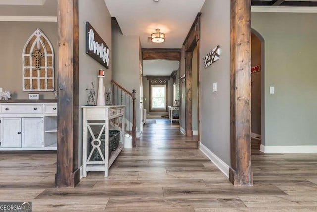 hallway featuring crown molding and light hardwood / wood-style flooring