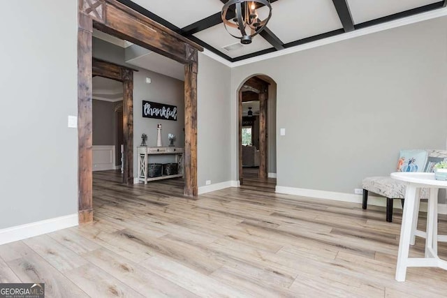 unfurnished dining area featuring coffered ceiling, hardwood / wood-style floors, beamed ceiling, and an inviting chandelier