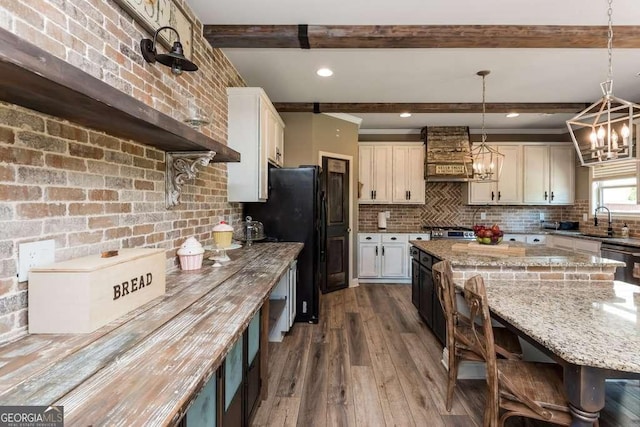 kitchen featuring sink, a center island, hanging light fixtures, stainless steel appliances, and beam ceiling