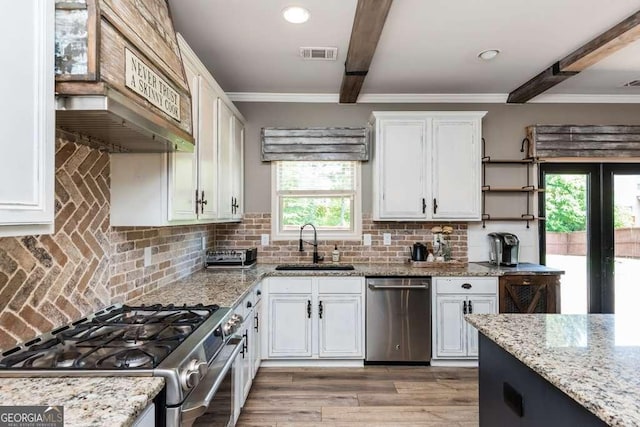 kitchen featuring beam ceiling, white cabinets, and appliances with stainless steel finishes