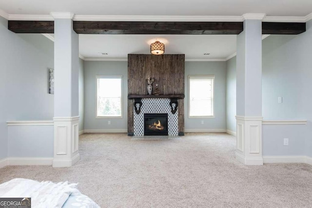 unfurnished living room featuring light carpet, ornamental molding, a fireplace, and decorative columns