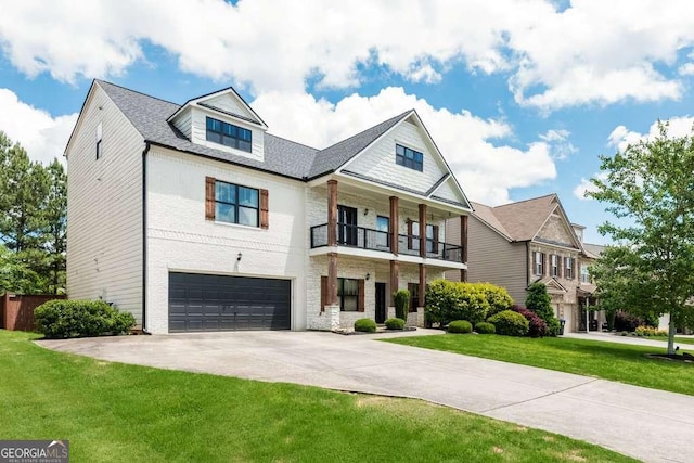 view of front of house featuring a balcony, a garage, and a front yard