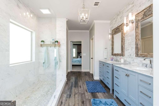 bathroom featuring decorative backsplash, hardwood / wood-style flooring, vanity, crown molding, and an inviting chandelier