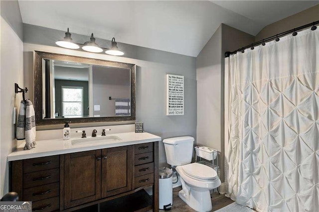 bathroom with vanity, curtained shower, vaulted ceiling, and toilet