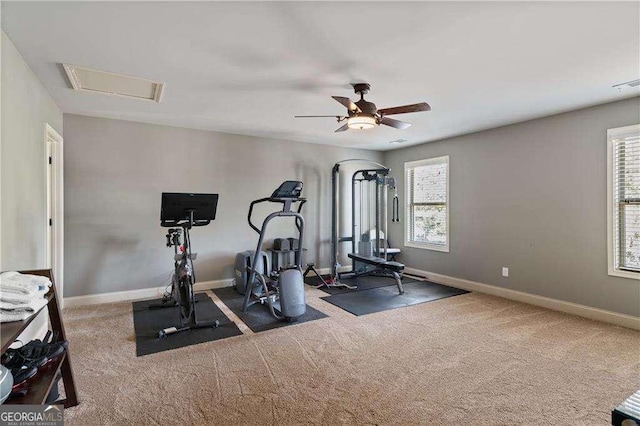 exercise room featuring dark colored carpet, a healthy amount of sunlight, and ceiling fan