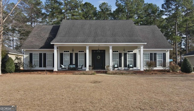 cape cod home featuring a porch and a front lawn