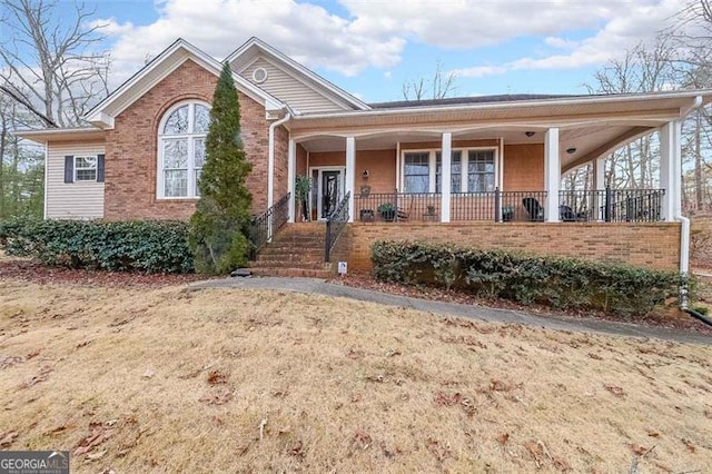 view of front property featuring covered porch and a front yard