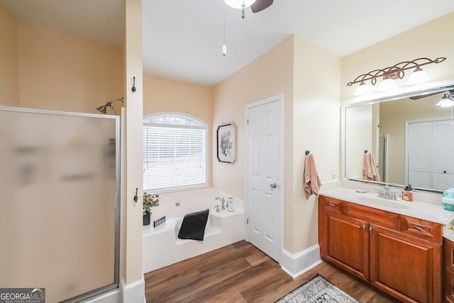 bathroom featuring vanity, wood-type flooring, plus walk in shower, and ceiling fan