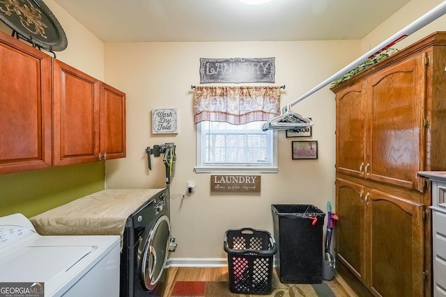 laundry room with cabinets, washing machine and dryer, and hardwood / wood-style floors