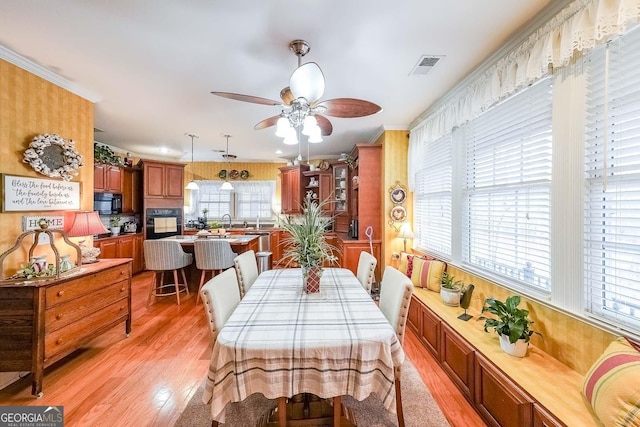 dining room with sink, light hardwood / wood-style flooring, and ceiling fan