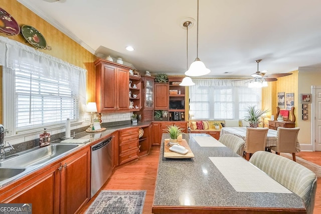 kitchen featuring crown molding, decorative light fixtures, dishwasher, a kitchen island, and ceiling fan