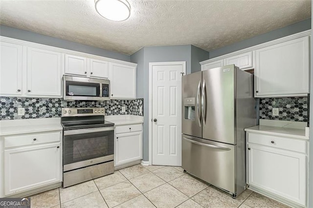 kitchen with white cabinetry, backsplash, light tile patterned floors, and stainless steel appliances