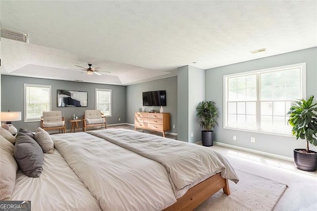 bedroom featuring light carpet, ceiling fan, and a textured ceiling