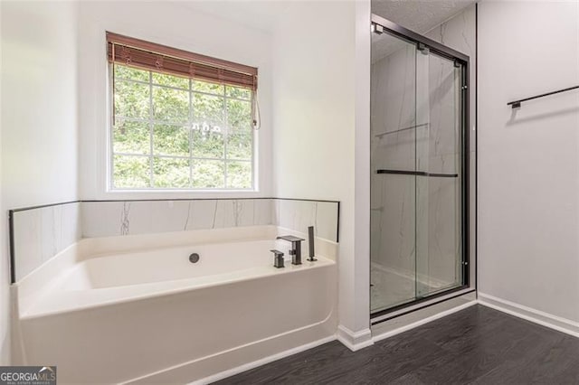 bathroom with independent shower and bath and hardwood / wood-style floors