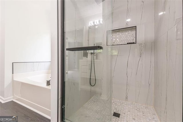 bathroom featuring independent shower and bath and hardwood / wood-style flooring